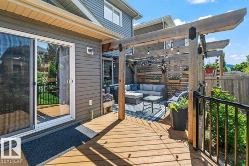 Spacious outdoor deck featuring natural wood planks, an integrated pergola structure, and direct access to the interior via sliding glass doors - 14 Edinburgh Crt N, St. Albert, AB 