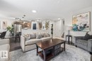 Open-concept living area featuring dark wood-finish flooring, recessed lighting, and a kitchen with stainless steel appliances and pendant lighting - 14 Edinburgh Crt N, St. Albert, AB 