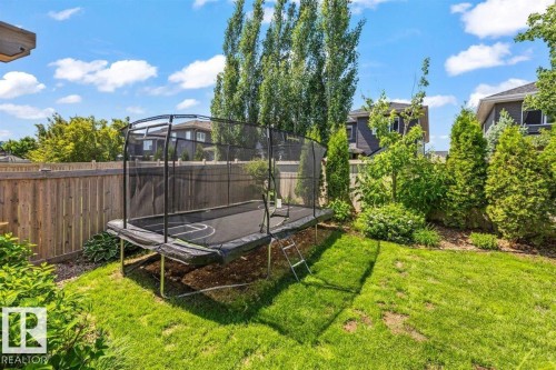 Expansive backyard featuring a lush lawn, mature trees, and privacy fencing - 14 Edinburgh Crt N, St. Albert, AB 