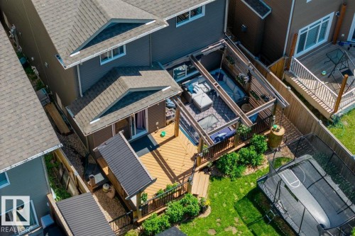Expansive backyard featuring a multi-level wood deck, a covered patio area with slatted roof, and a perimeter fence - 14 Edinburgh Crt N, St. Albert, AB 
