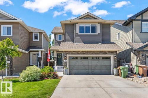 Two-story property featuring a stone and siding facade, a two-car garage, and a concrete driveway - 14 Edinburgh Crt N, St. Albert, AB 