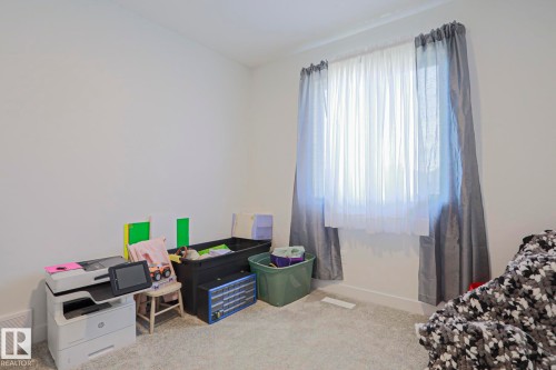 Room featuring light gray carpeting and white baseboards - 33 Eton Link, Spruce Grove, AB 