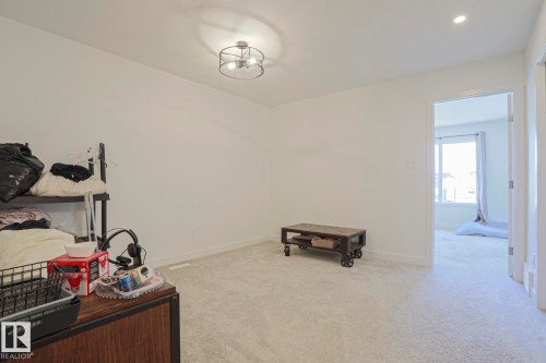 Bright interior space featuring light-colored carpeting and white wall finishes - 33 Eton Link, Spruce Grove, AB 