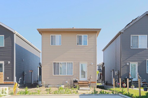 Two-story residence featuring light beige siding and a light brown roofline - 33 Eton Link, Spruce Grove, AB 