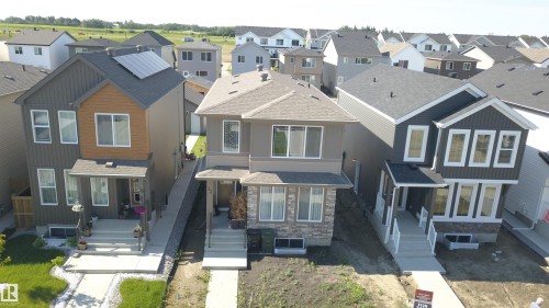 Modern two-story home with a dark gray exterior, white trim, and a prominent front porch - 33 Eton Link, Spruce Grove, AB 