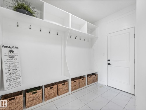 White built-in storage system with cubbies and hooks, featuring a bench seat and overhead shelving - 5411 66 Street, Beaumont, AB 