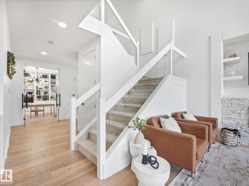 Modern staircase featuring carpeted treads and clear glass railings - 5411 66 Street, Beaumont, AB 