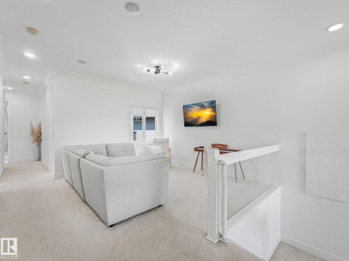 Carpeted upper-level landing featuring a window, recessed lighting, and panel molding - 5411 66 Street, Beaumont, AB 