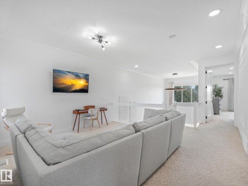 Open concept upper-level space featuring light-colored carpeting, white walls, and recessed lighting - 5411 66 Street, Beaumont, AB 