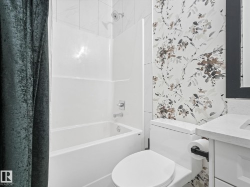 Bathroom featuring a white bathtub and shower combination with chrome fixtures - 5411 66 Street, Beaumont, AB 