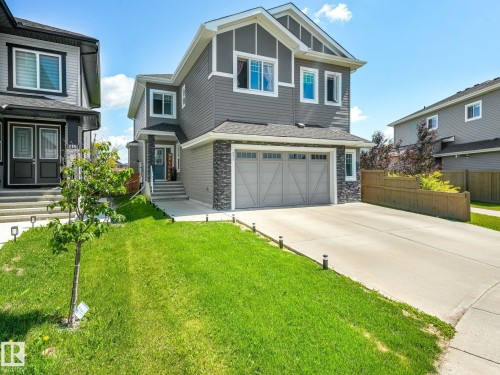 Modern two-story residence featuring grey siding and a stone accent facade - 5411 66 Street, Beaumont, AB 