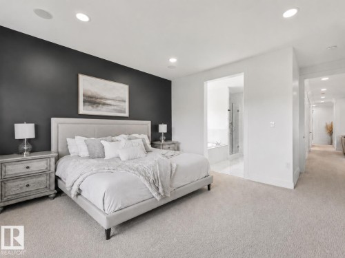 Carpeted bedroom with a dark accent wall and recessed lighting - 5411 66 Street, Beaumont, AB 