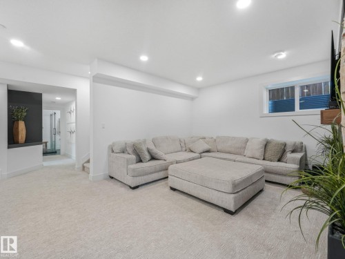 Open-concept living space with recessed lighting and neutral-toned carpeting - 5411 66 Street, Beaumont, AB 