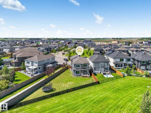 Two-story residence with a covered patio, rear deck, and fenced yard backing onto a green space - 5411 66 Street, Beaumont, AB 