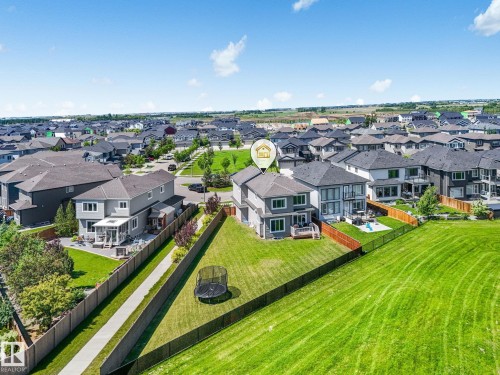 Expansive green space bordering the property with a black chain-link fence - 5411 66 Street, Beaumont, AB 