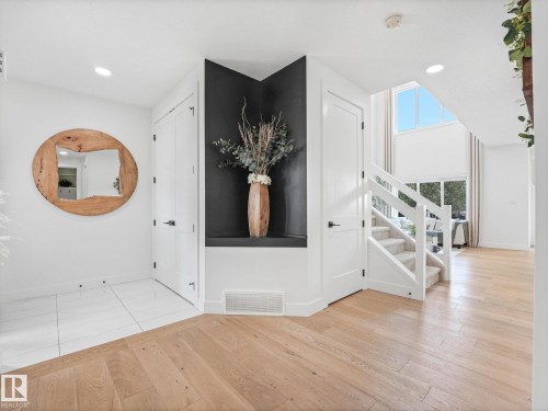 Entry foyer featuring light wood-finish flooring transitioning to large format white floor tiles - 5411 66 Street, Beaumont, AB 