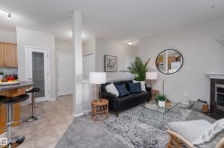 Living area featuring a fireplace with dark tile surround, light gray wall paint, and recessed lighting - 