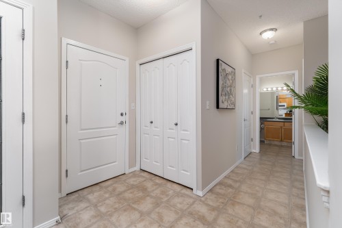 Entryway featuring patterned tile flooring and a white paneled entry door - 404 12111 51 Avenue, Edmonton, AB 