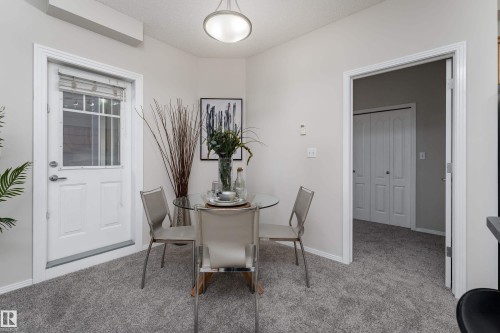 Dining area featuring gray carpet flooring and light-toned wall paint - 404 12111 51 Avenue, Edmonton, AB 