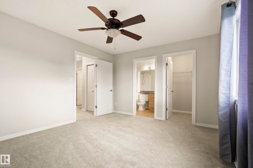 Carpeted room featuring a ceiling fan, light gray wall paint, and white trim - 2369 27 Avenue, Edmonton, AB 