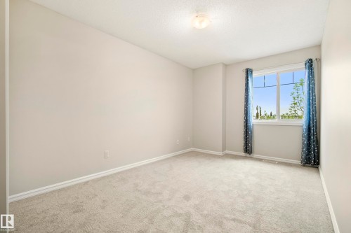 Carpeted room with a double-paned window and neutral wall paint - 2369 27 Avenue, Edmonton, AB 