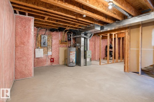 Unfinished basement featuring exposed wood joists, concrete flooring, and partial wall insulation - 2369 27 Avenue, Edmonton, AB 