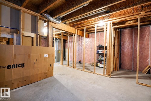 Basement framing providing structure for future rooms, exposed ceiling joists, concrete flooring, and visible insulation - 2369 27 Avenue, Edmonton, AB 