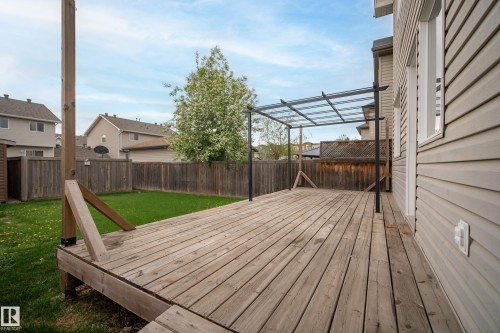 Expansive wooden deck featuring a contemporary pergola with a clear roof, providing an outdoor extension to the residence - 2369 27 Avenue, Edmonton, AB 