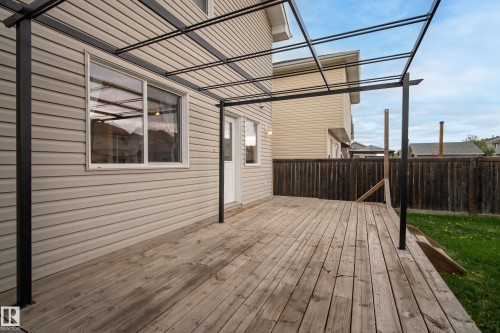 Spacious wood deck with an attached black metal pergola frame - 2369 27 Avenue, Edmonton, AB 