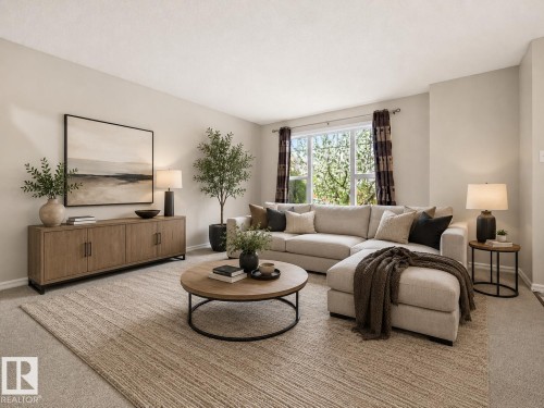 Living area featuring neutral wall tones, large window with outdoor greenery, wood-finish console table, and carpeted flooring - 2369 27 Avenue, Edmonton, AB 