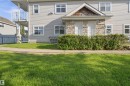 Manicured lawn fronting a multi-unit property with light-colored siding - 95 3040 Spence Wynd, Edmonton, AB 