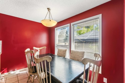 Dining area with red walls and neutral-toned tile flooring - 14121 23 Street, Edmonton, AB 