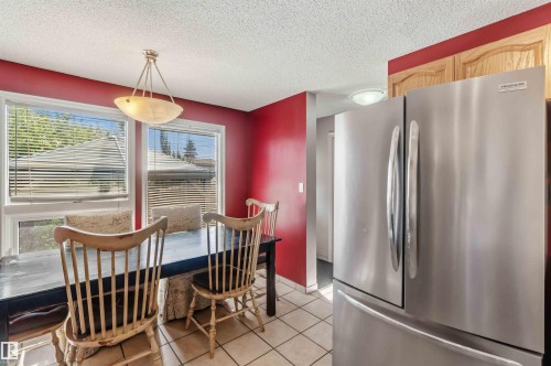 Dining area featuring a stainless steel French door refrigerator - 14121 23 Street, Edmonton, AB 