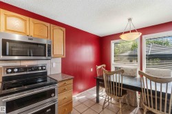 Kitchen area featuring wood cabinetry, stainless steel microwave, and an electric range with a double oven - 