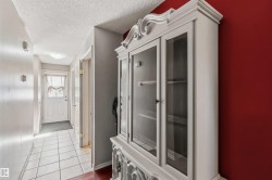 Foyer with white paneled door, ceiling-mounted light fixture, and tile flooring - 