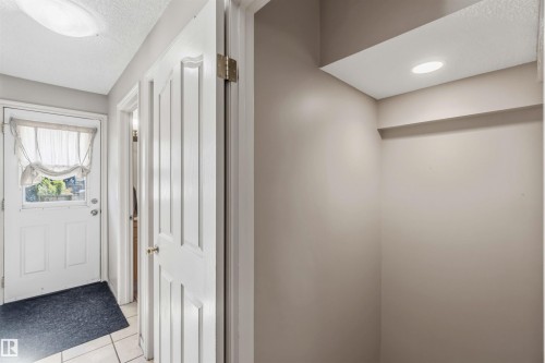 Entryway featuring a white paneled door with glass insert, ceramic tile flooring, and neutral wall tones - 14121 23 Street, Edmonton, AB 