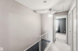 Second-level hallway featuring light gray walls, white railing, and a modern ceiling fan with integrated lighting - 