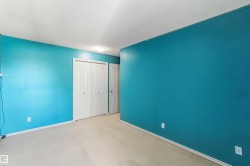Room featuring light-colored carpeting, vibrant blue wall paint, white trim, and a flush-mounted ceiling light fixture - 