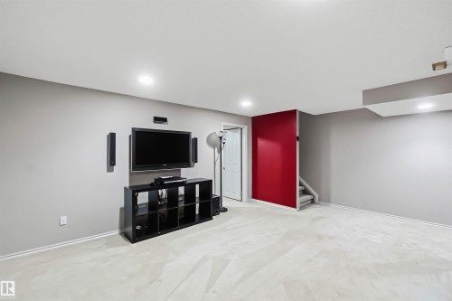 Spacious room featuring light-toned carpeting, recessed ceiling lighting, and a neutral wall palette - 14121 23 Street, Edmonton, AB 