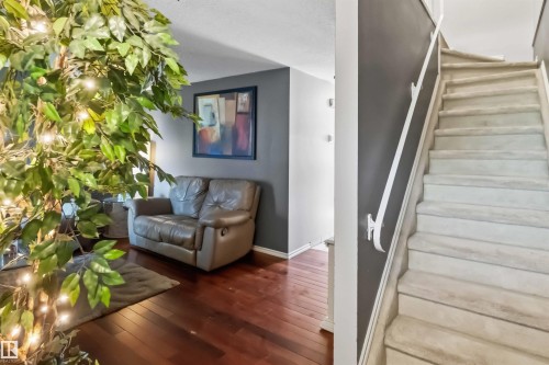 Carpeted staircase with white handrail leading to upper level - 14121 23 Street, Edmonton, AB 
