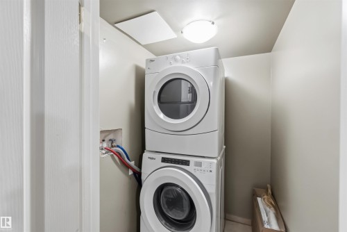 Dedicated laundry space featuring a stacked washer and dryer unit - 14121 23 Street, Edmonton, AB 