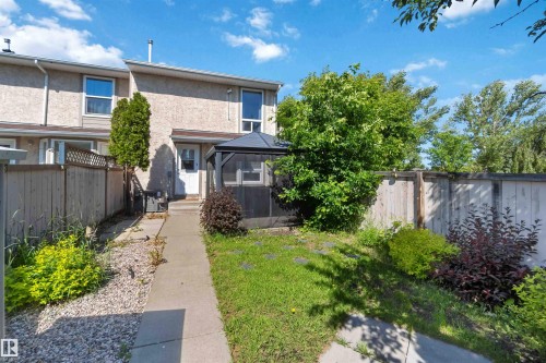 Rear exterior featuring a screened gazebo, a concrete pathway, and a gravel bed - 14121 23 Street, Edmonton, AB 