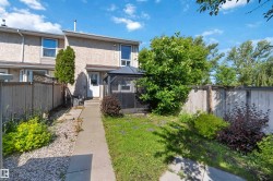 Rear exterior featuring a screened gazebo, a concrete pathway, and a gravel bed - 