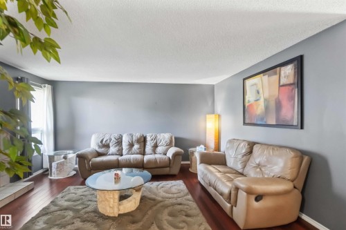 Spacious living area featuring rich wood-finish flooring and neutral wall tones - 14121 23 Street, Edmonton, AB 