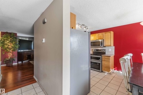 Kitchen area featuring light wood cabinetry, stainless steel appliances, and a tile backsplash - 14121 23 Street, Edmonton, AB 