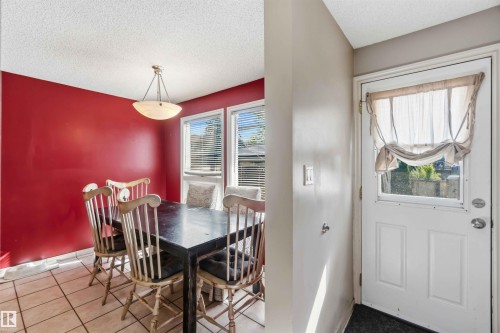 Dining area featuring bold red walls and tiled flooring - 14121 23 Street, Edmonton, AB 