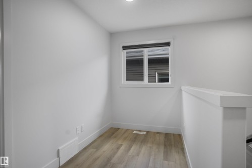 Bright space featuring neutral white walls and wood-finish flooring - 1915 164 Street, Edmonton, AB 
