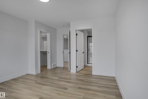Neutral wall tones, wood-finish flooring, and crisp white trim - 1915 164 Street, Edmonton, AB 