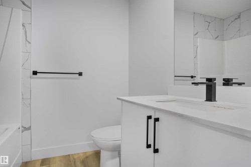 Contemporary bathroom featuring a white vanity with a white countertop and integrated sink - 1915 164 Street, Edmonton, AB 