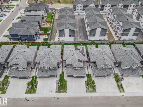 Contemporary residential neighborhood featuring a collection of detached homes and townhomes with gray shingle roofs, private driveways, and landscaped front yards - 1915 164 Street, Edmonton, AB 